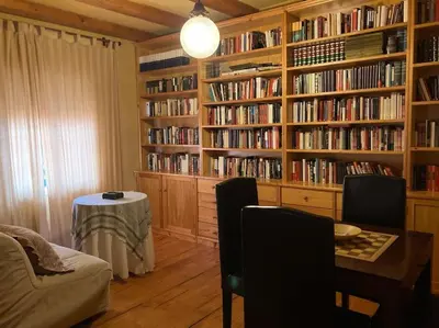a room with a library with book shelves filled with books at Al sur del sur in Sanlúcar de Barrameda