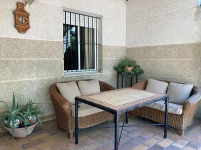 two wicker chairs and a table on a patio at Al sur del sur in Sanlúcar de Barrameda
