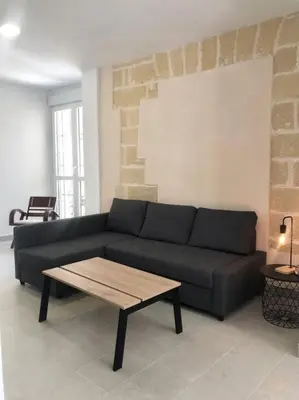 a living room with a black couch and a coffee table at Apartamento en Plaza Plateros in Jerez de la Frontera
