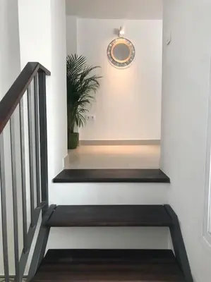 a staircase with a clock on the wall and a plant at Apartamento en Plaza Plateros in Jerez de la Frontera