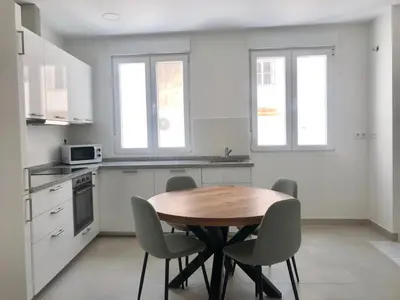 a kitchen with a wooden table and chairs at Apartamento en Plaza Plateros in Jerez de la Frontera