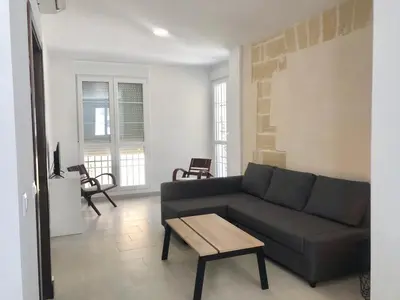 a living room with a couch and a table at Apartamento en Plaza Plateros in Jerez de la Frontera