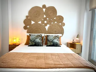 a bedroom with a large bed with a large headboard at MyChoice Frida in Rota