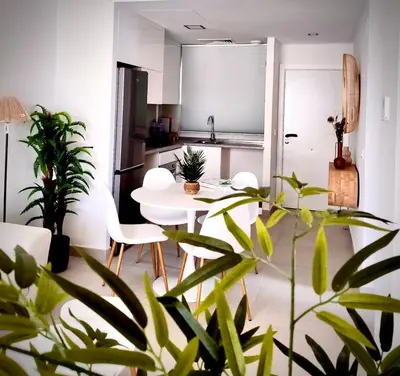 a living room with a table and chairs and plants at MyChoice Frida in Rota
