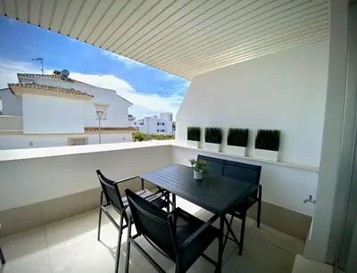 a black table and chairs on a balcony with a building at MyChoice Frida in Rota