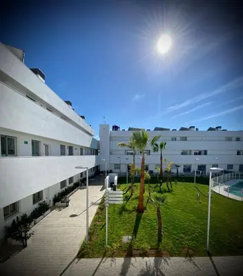a courtyard with palm trees in front of a building at MyChoice Frida in Rota