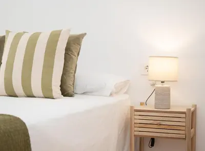 a bedroom with a bed and a lamp on a night stand at SibsSanlucar Duquesa Loft Coqueto Ideal Parejas in Sanlúcar de Barrameda