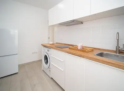 a white kitchen with a sink and a dishwasher at SibsSanlucar Duquesa Loft Coqueto Ideal Parejas in Sanlúcar de Barrameda
