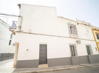 a white building with a black door on a street at SibsSanlucar Duquesa Loft Coqueto Ideal Parejas in Sanlúcar de Barrameda