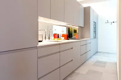 a kitchen with white cabinets and a sink at Genteel Home Catedral Cádiz in Cádiz
