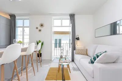 a white living room with a white couch and a table at Genteel Home Catedral Cádiz in Cádiz