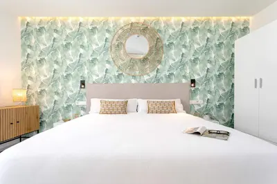a bedroom with a large white bed and a mirror at Genteel Home Catedral Cádiz in Cádiz