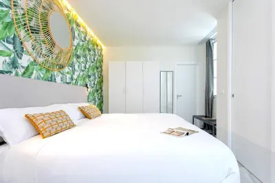 a bedroom with a large white bed and a mirror at Genteel Home Catedral Cádiz in Cádiz