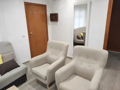 a living room with two chairs and a mirror at Arco Centro Cádiz in Cádiz