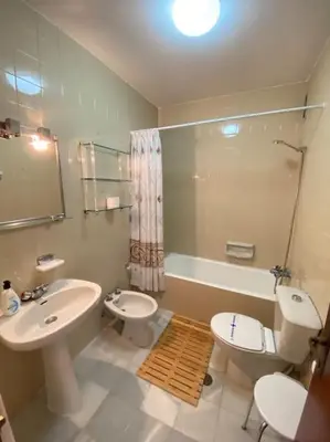 a bathroom with a sink and a toilet and a tub at Apartamento Acuario in Sanlúcar de Barrameda