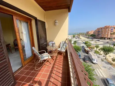 a balcony with a table and chairs and a view of a city at Apartamento Acuario in Sanlúcar de Barrameda
