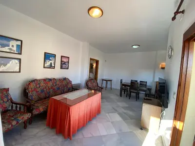 a living room with a couch and a table at Apartamento Acuario in Sanlúcar de Barrameda