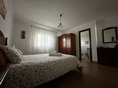 a bedroom with a bed with a white bedspread at Casa Campiña Jerezana in Torrecera