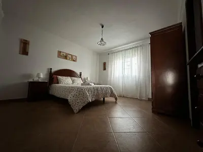 a bedroom with a bed and a dresser and a window at Casa Campiña Jerezana in Torrecera