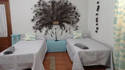 a room with two beds and a potted plant at El Amanecer in El Puerto de Santa María