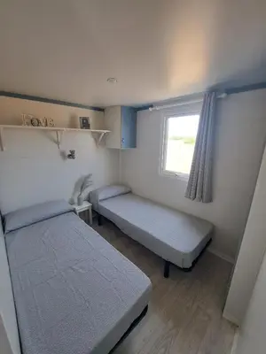 a small room with two beds and a window at Apartamento el ronco. in Conil de la Frontera