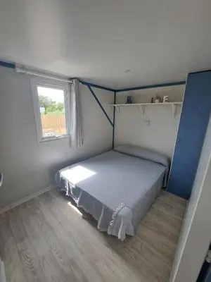 a small bedroom with a bed and a window at Apartamento el ronco. in Conil de la Frontera