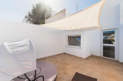 a white room with a chair and a window at Jacuzzi Amanecer de Plata Decoración Romántica in Chiclana de la Frontera