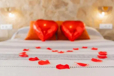 two hearts sitting on a bed with red hearts on it at Jacuzzi Amanecer de Plata Decoración Romántica in Chiclana de la Frontera