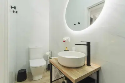 a bathroom with a sink and a toilet and a mirror at Jacuzzi Amanecer de Plata Decoración Romántica in Chiclana de la Frontera