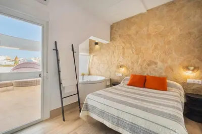 a bedroom with a bed and a bathroom with a tub at Jacuzzi Amanecer de Plata Decoración Romántica in Chiclana de la Frontera
