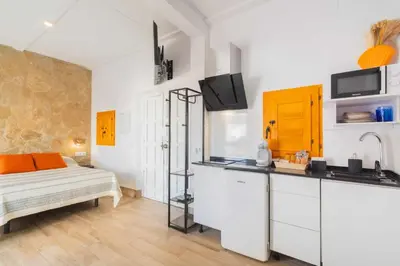a white kitchen with a bed and a sink at Jacuzzi Amanecer de Plata Decoración Romántica in Chiclana de la Frontera