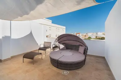 a room with a bed and two chairs on a balcony at Jacuzzi Amanecer de Plata Decoración Romántica in Chiclana de la Frontera