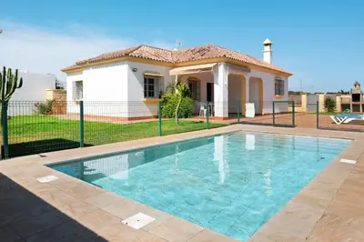 a swimming pool in front of a house at CHALET ROBLES in Cádiz