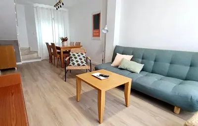 a living room with a blue couch and a table at Las Américas by RentCadiz in El Puerto de Santa María