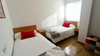 a small room with two beds and a window at Las Américas by RentCadiz in El Puerto de Santa María