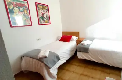 a bedroom with two beds and two posters on the wall at Las Américas by RentCadiz in El Puerto de Santa María