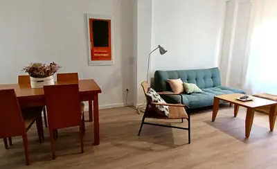 a living room with a blue couch and a table at Las Américas by RentCadiz in El Puerto de Santa María