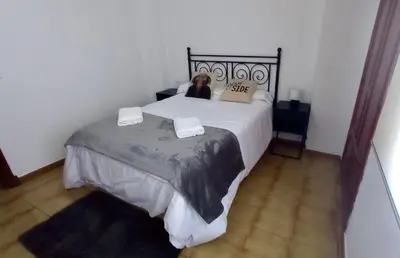 a woman laying on a bed in a bedroom at Las Américas by RentCadiz in El Puerto de Santa María