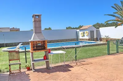 a playground in a fence next to a pool at Chalet Cielo Azul in Conil de la Frontera