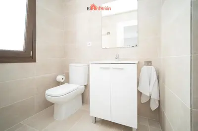 a bathroom with a toilet and a sink and a mirror at Banda Playa - Arizón in Sanlúcar de Barrameda
