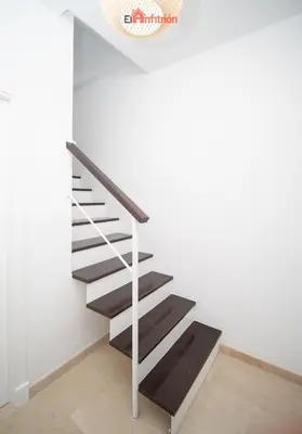 a staircase with black treads and a metal railing at Banda Playa - Arizón in Sanlúcar de Barrameda
