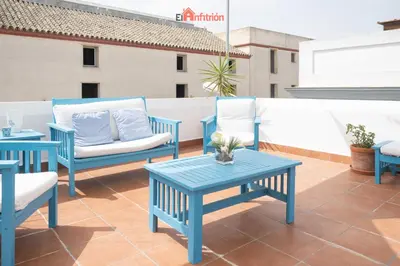 a patio with blue chairs and tables on a roof at Banda Playa - Arizón in Sanlúcar de Barrameda