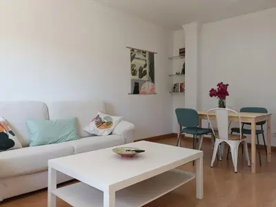 a living room with a white couch and a table at 2 dormitorios y muy fácil aparcamiento in Jerez de la Frontera