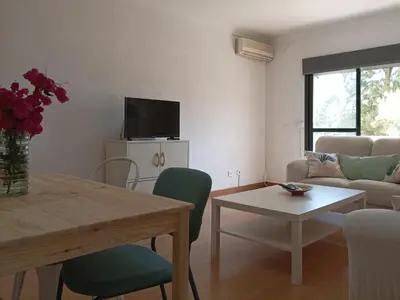 a living room with a table and a couch at 2 dormitorios y muy fácil aparcamiento in Jerez de la Frontera