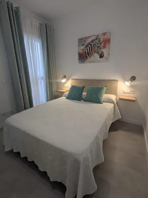 a bedroom with a bed with two pillows on it at Apartamento Al Andalus. La Barrosa. in Chiclana de la Frontera