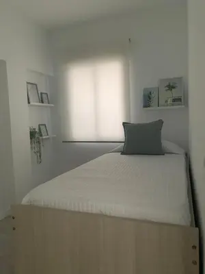 a bed in a white room with a window at Apartamento Al Andalus. La Barrosa. in Chiclana de la Frontera