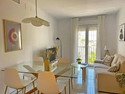 a living room with a glass table and chairs at Apartamento El Carmen - Ole Solutions in Jerez de la Frontera