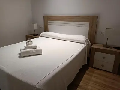 a bedroom with two white towels on a bed at Apartamento interior en Rosario in Cádiz