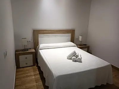 a bedroom with a bed with two shoes on it at Apartamento interior en Rosario in Cádiz