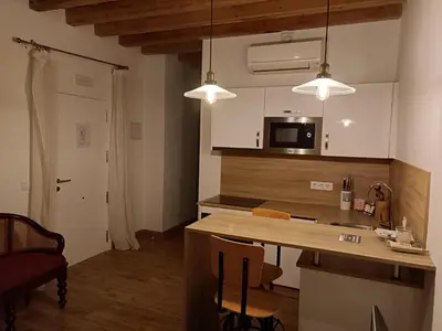a kitchen with a counter and a kitchen island with chairs at Apartamento interior en Rosario in Cádiz